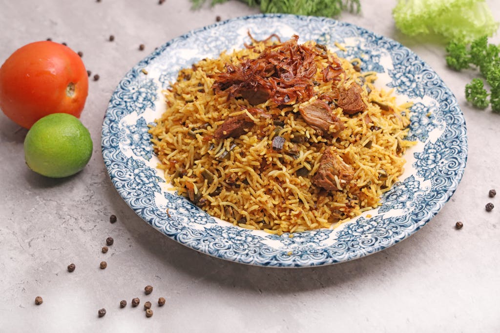 A flavorful biryani dish with succulent meat, served with herbs and spices, perfect for food photography.